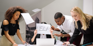 a group of people in an office with a sign that says help