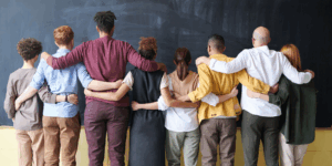 a group of people standing in front of a blackboard