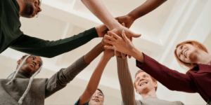 a group of people putting their hands together
