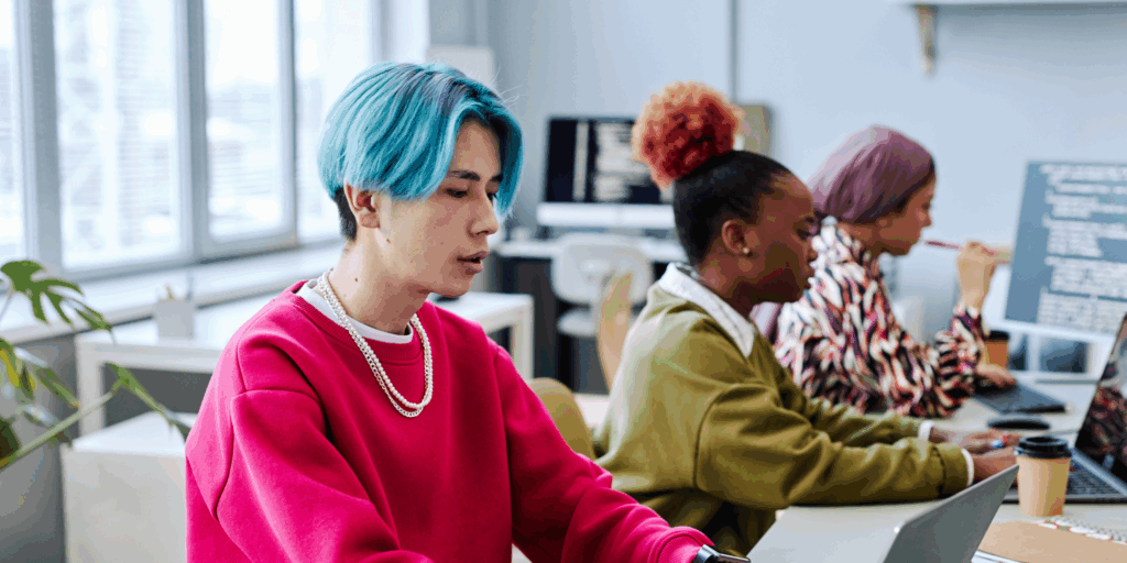 a group of people working on laptops in an office